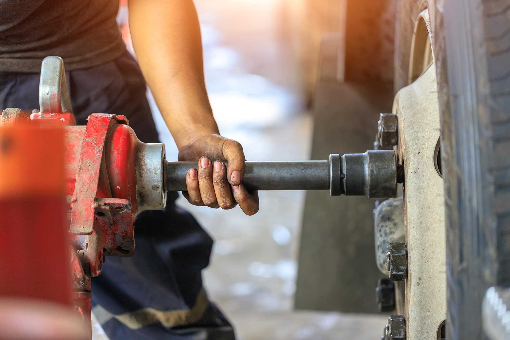A construction worker, wearing safety gear, is operating a large concrete mixing truck, managing the flow of concrete into a funnel.